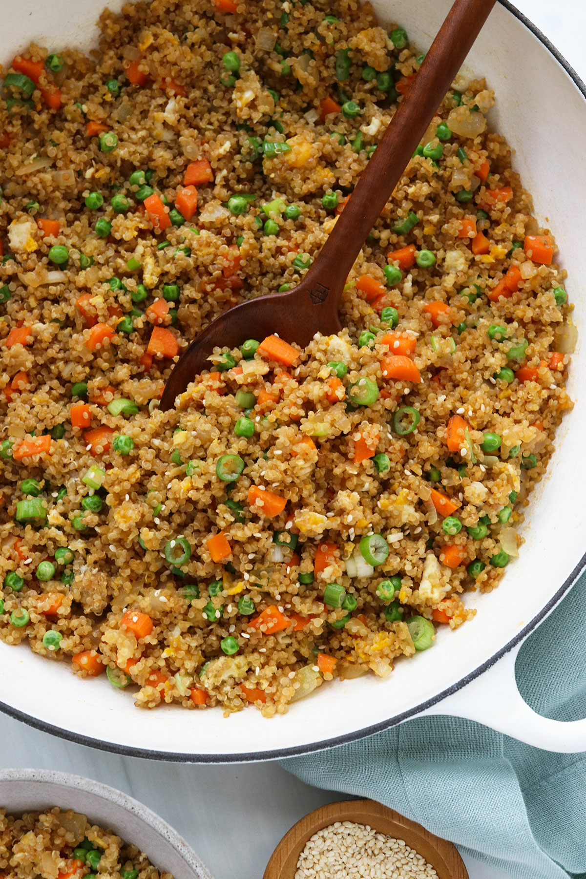 quinoa fried rice in white pan with serving spoon.