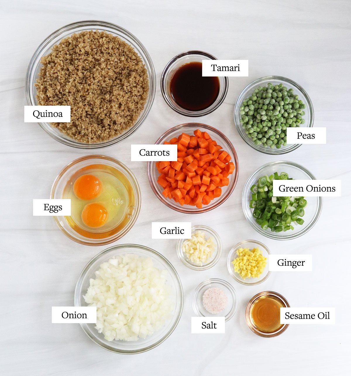 quinoa fried rice ingredients labeled in glass bowls.
