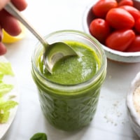 pesto salad dressing with spoon in the jar.