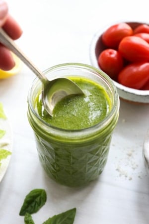 pesto salad dressing with spoon in the jar.