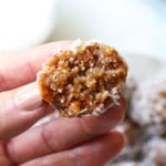 hand holding half of a date energy ball to show the texture.