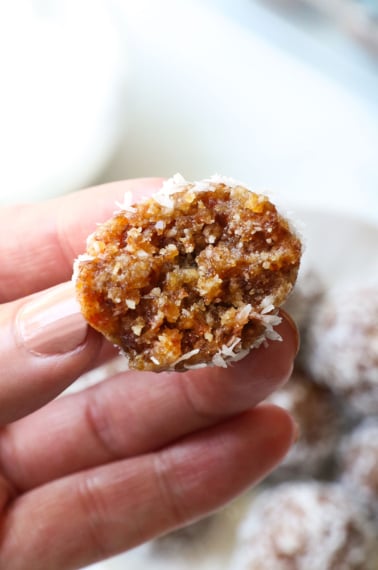 hand holding half of a date energy ball to show the texture.