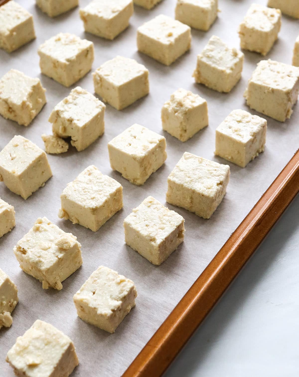 tofu arranged on a baking sheet with parchment paper.