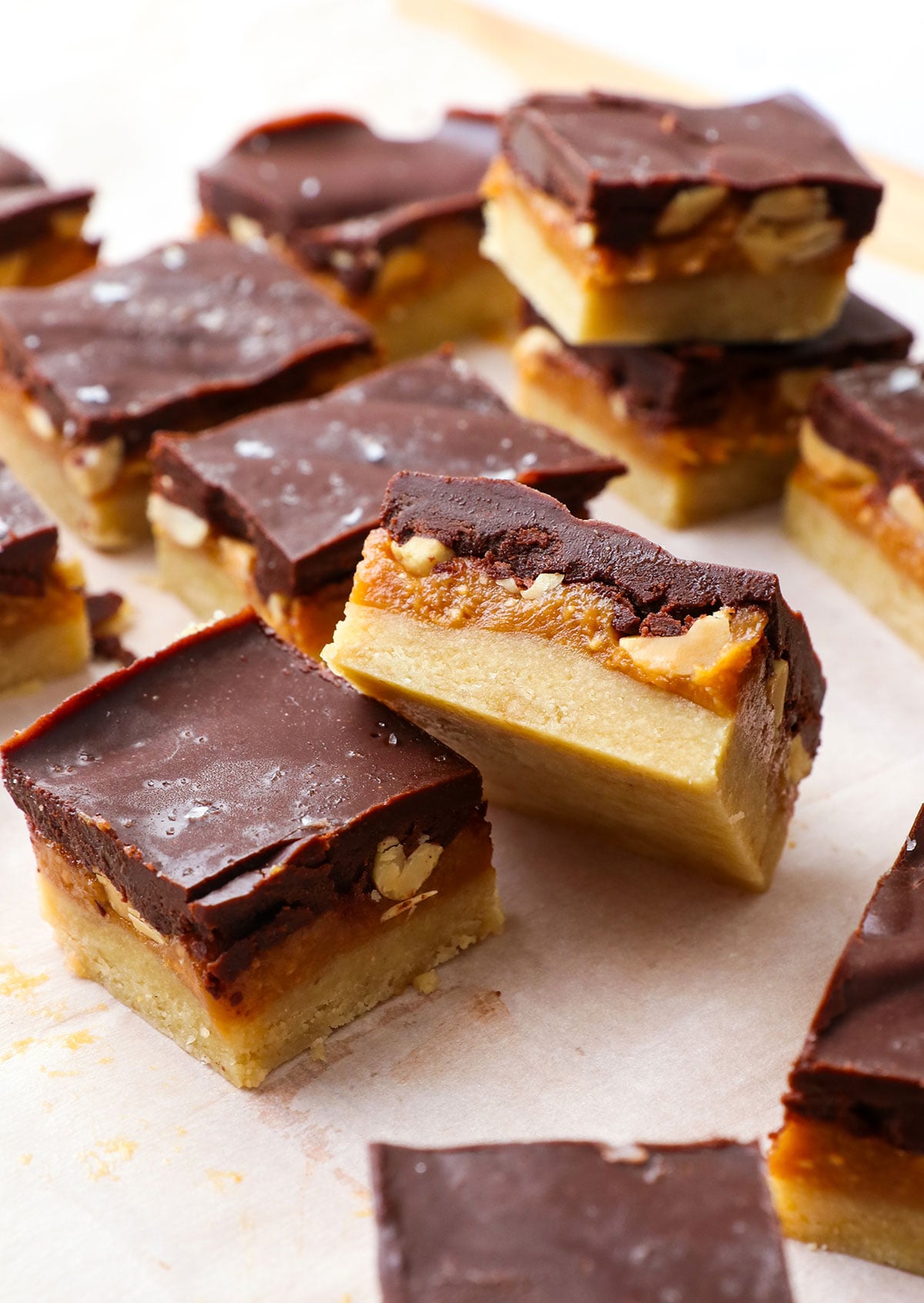 two healthy snickers bars cut on a parchment lined cutting board. 