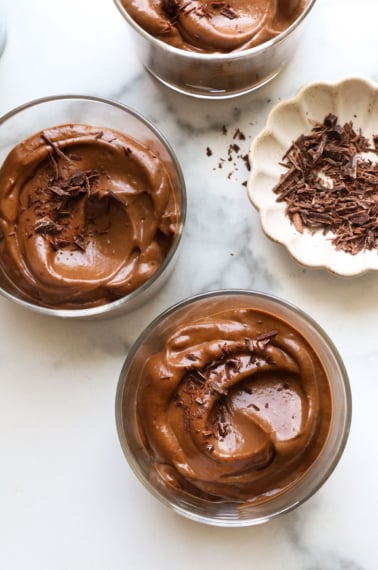 chocolate avocado pudding served in 3 glass jars.