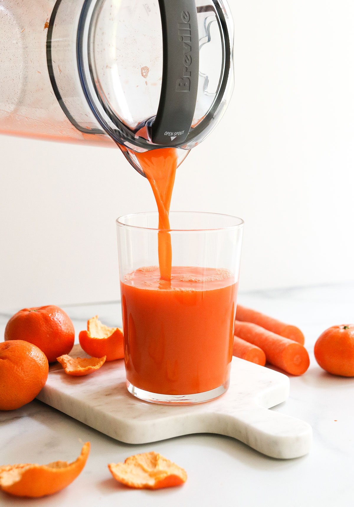 Carrot juice poured into a glass from a direct angle.