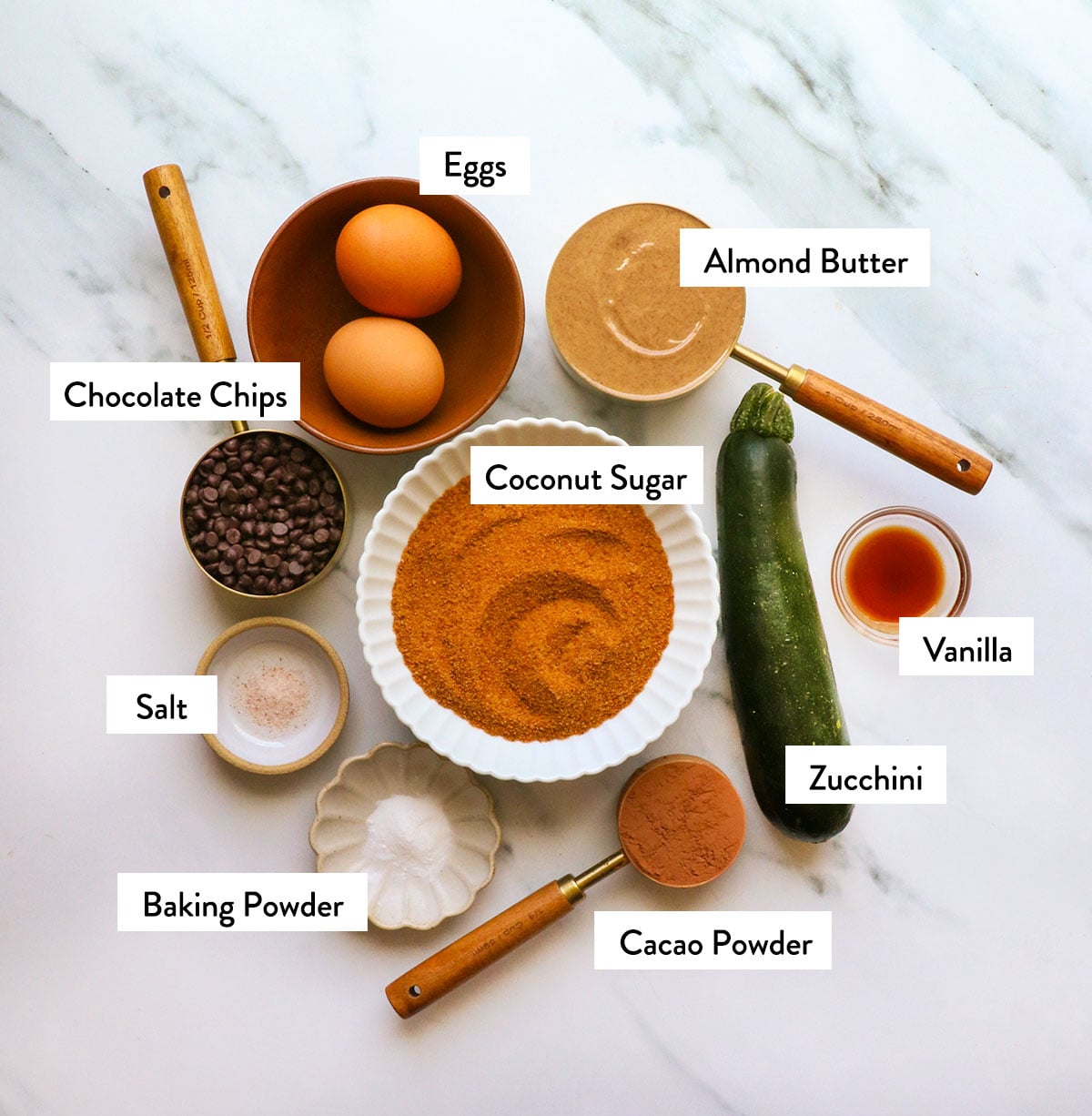 coconut sugar, eggs, zucchini, and almond butter labeled for muffins. 