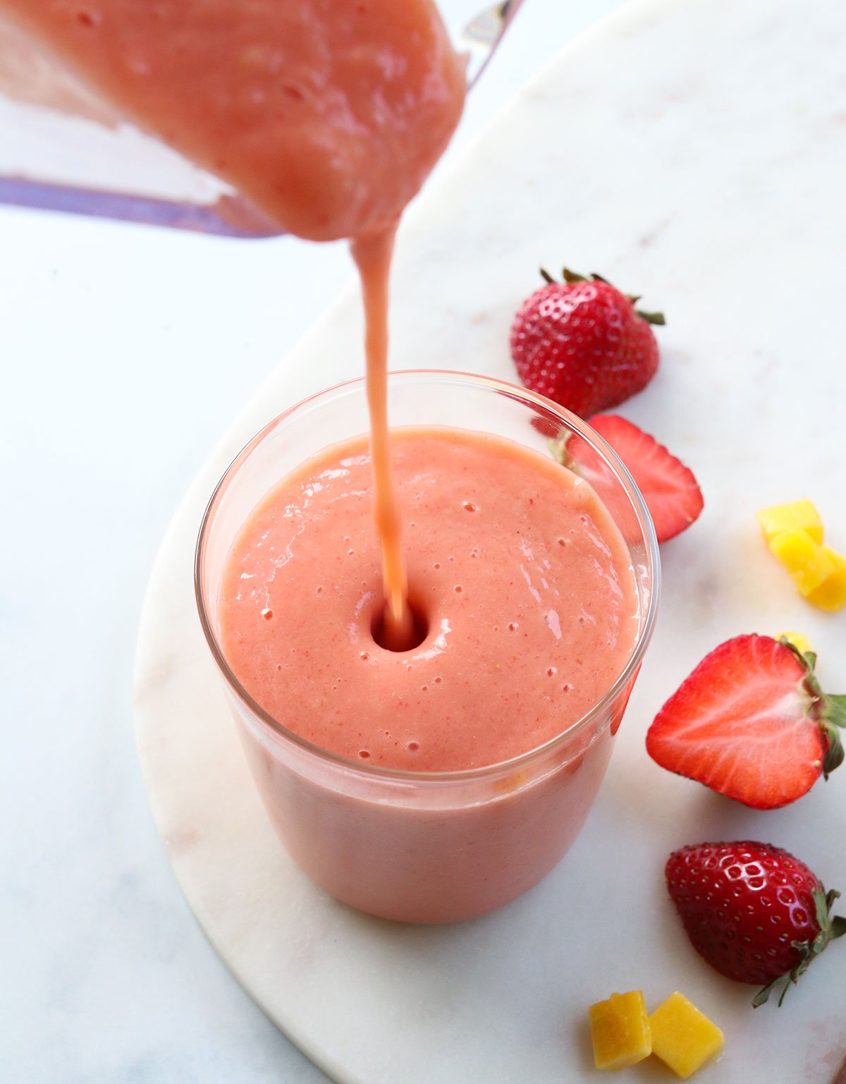 strawberry mango smoothie poured into a small glass.