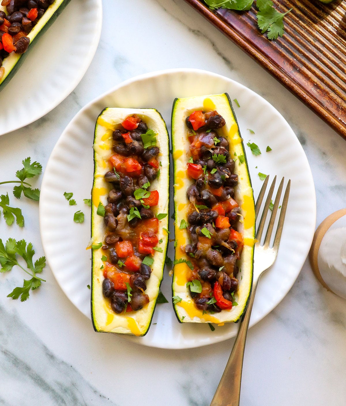 vegetarian stuffed zucchini with black beans and melted cheese.