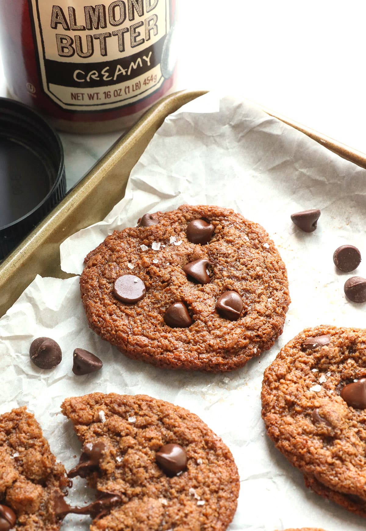 almond butter cookies topped with chocolate chips on a pan.