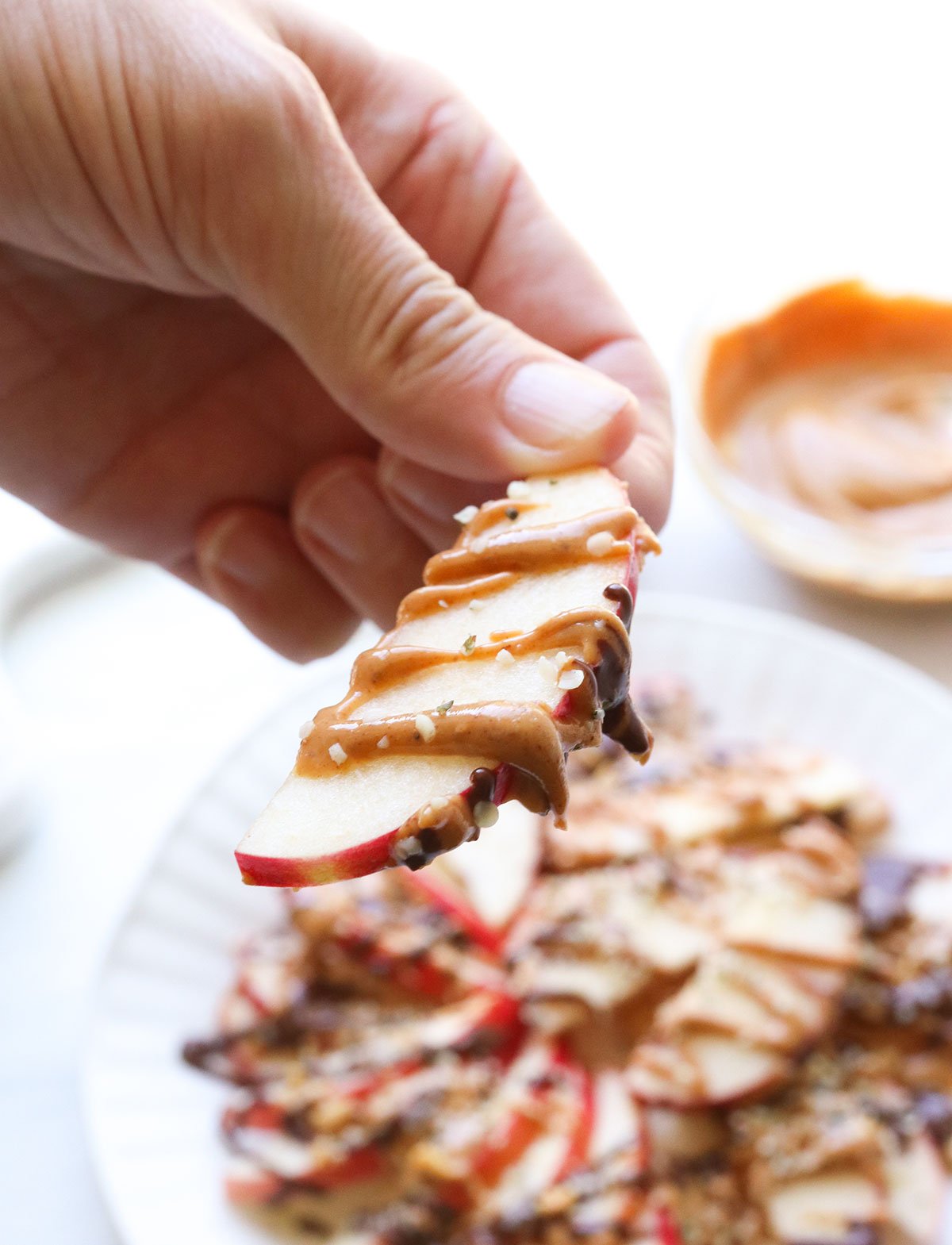 apple nacho sliced held by a hand.