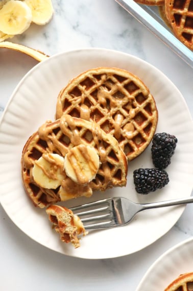 protein waffles close up on a white plate with bananas.
