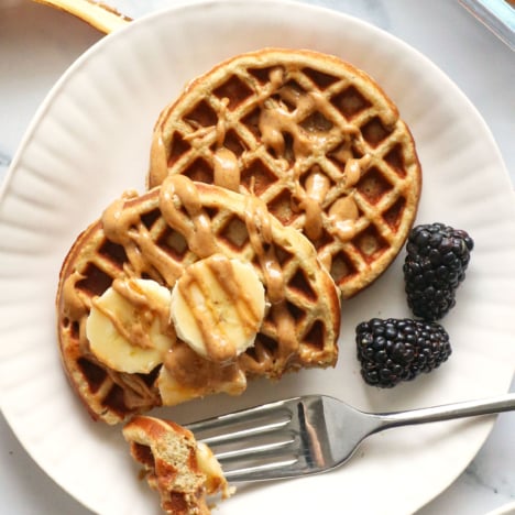 protein waffles close up on a white plate with bananas.