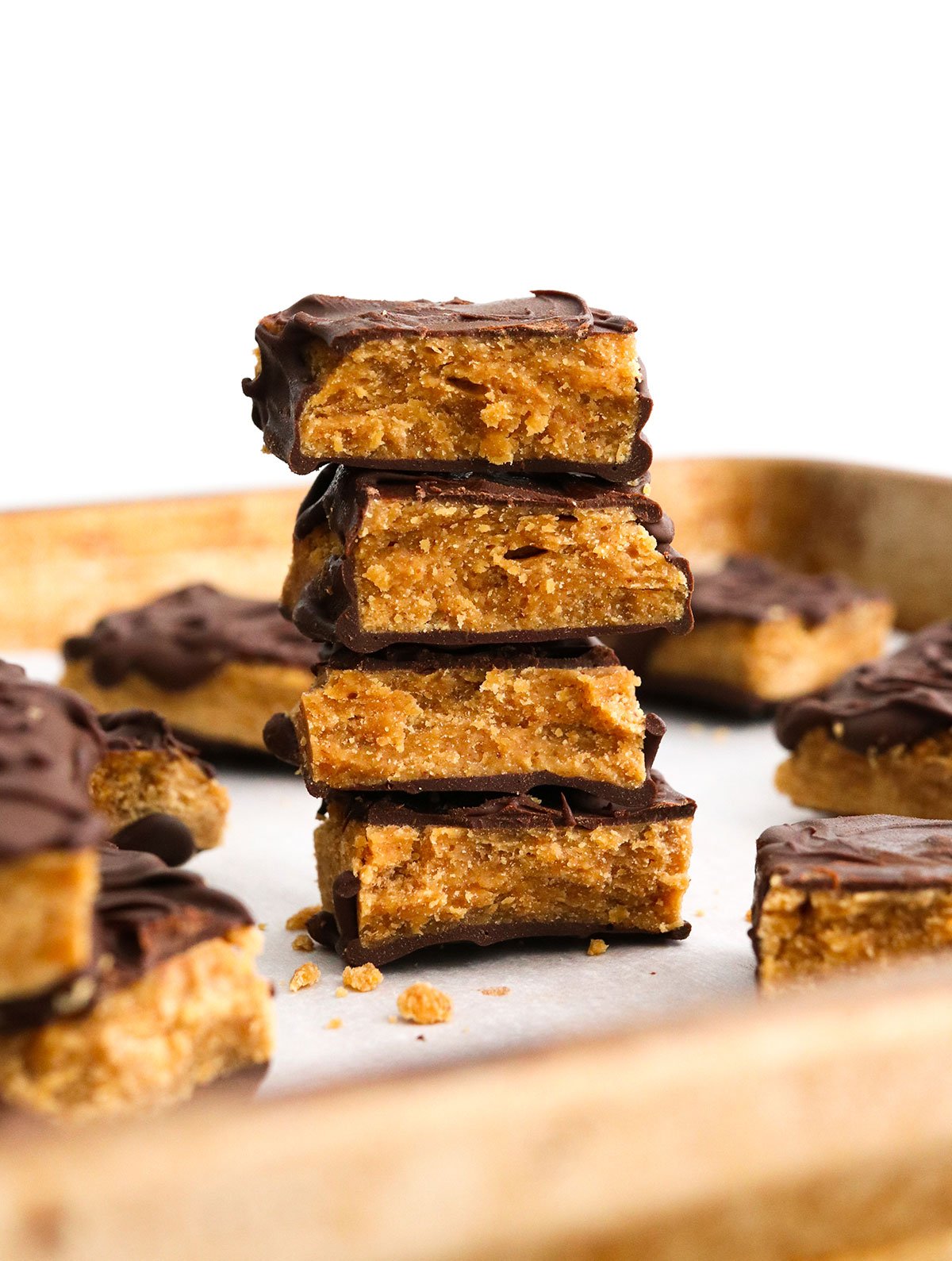 homemade butterfingers stacked on a baking sheet with white background.