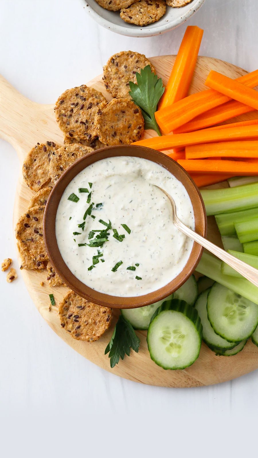 cottage cheese dip in a bowl served with crackers and veggies.