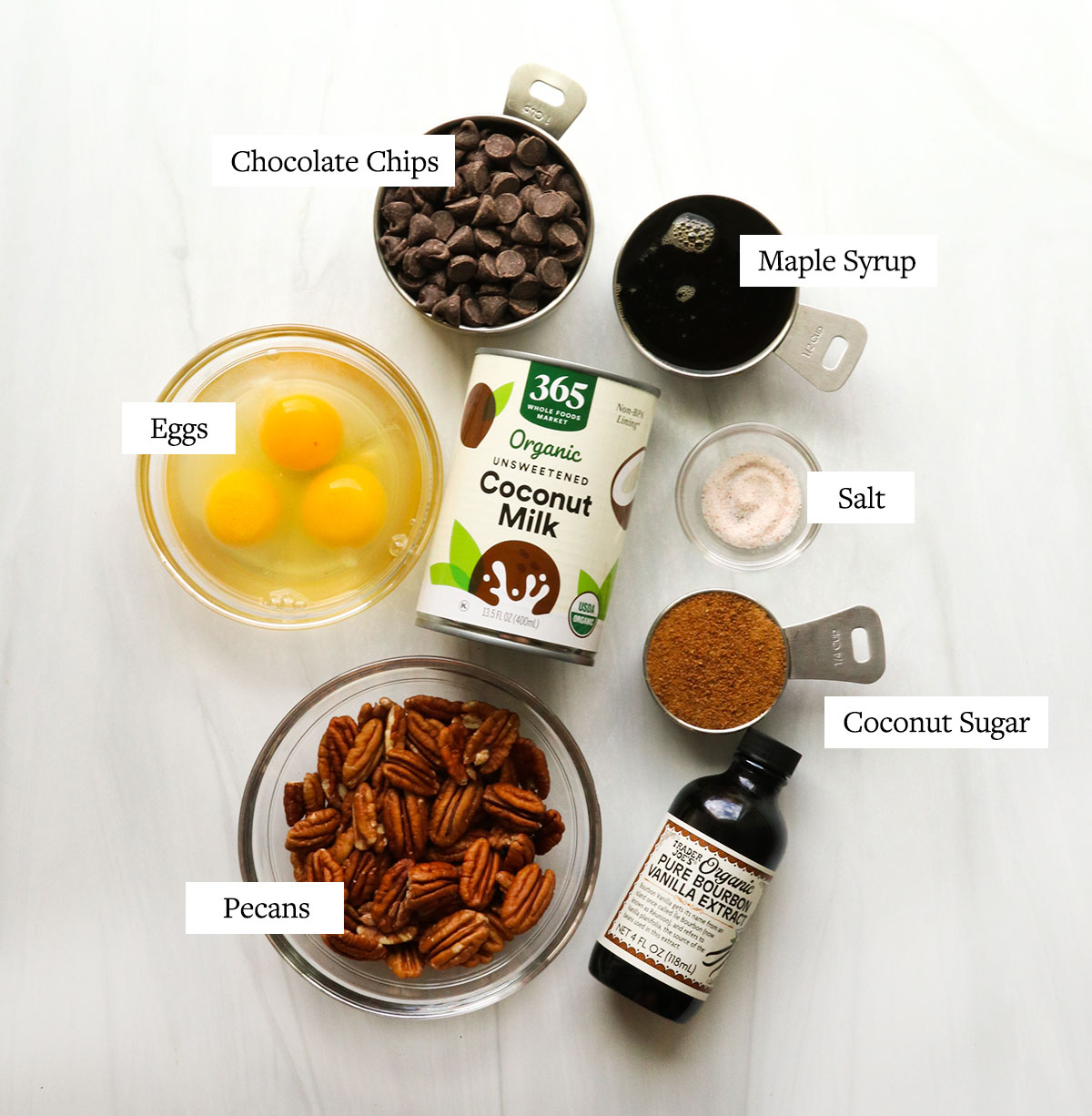 chocolate pecan pie ingredients labeled on a white surface.