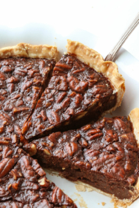Chocolate pecan pie slice lifted up from a pie pan.