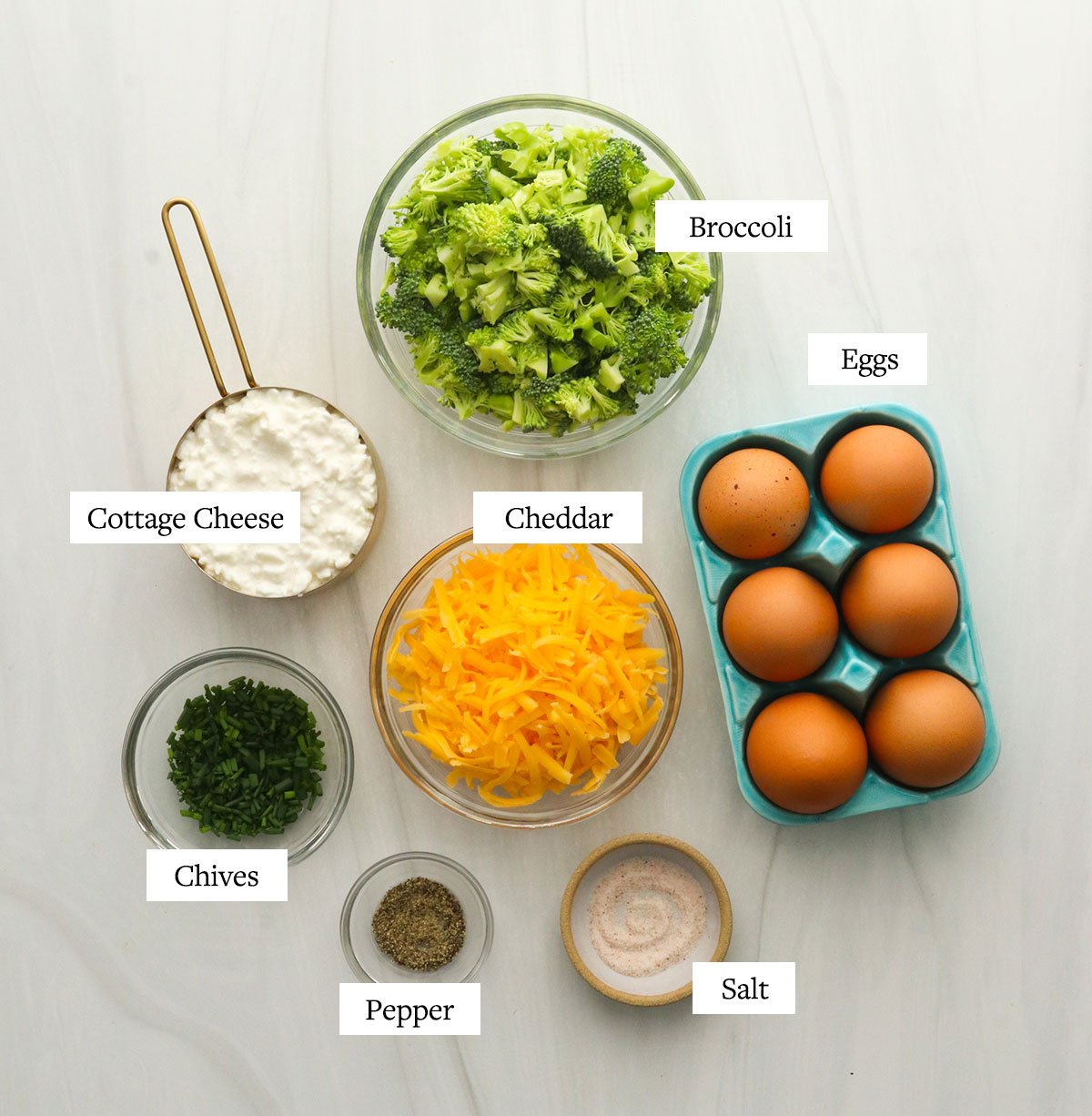 crustless quiche ingredients labeled on a white surface.