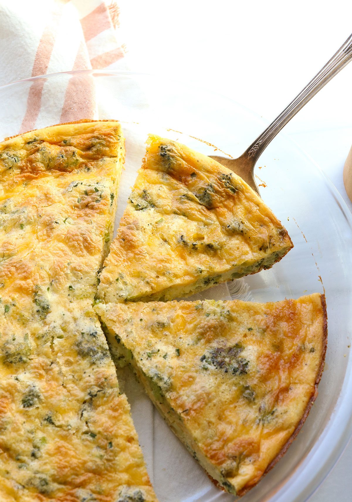 crustless quiche sliced and lifted with a cake server.