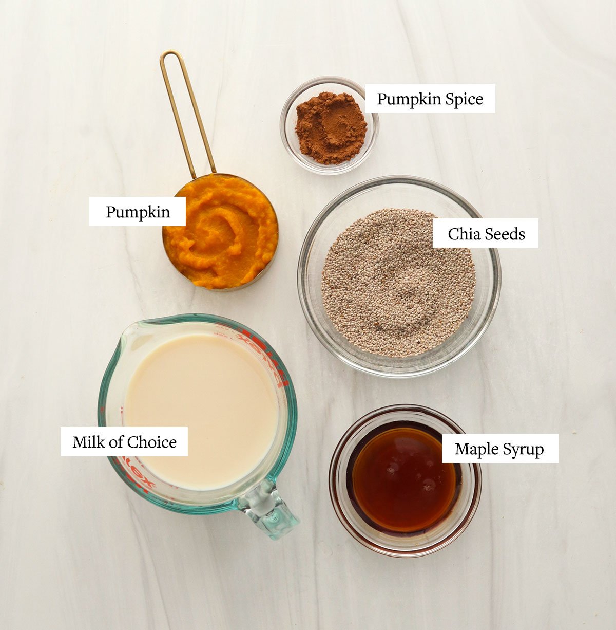 pumpkin chia pudding ingredients labeled in glass bowls.