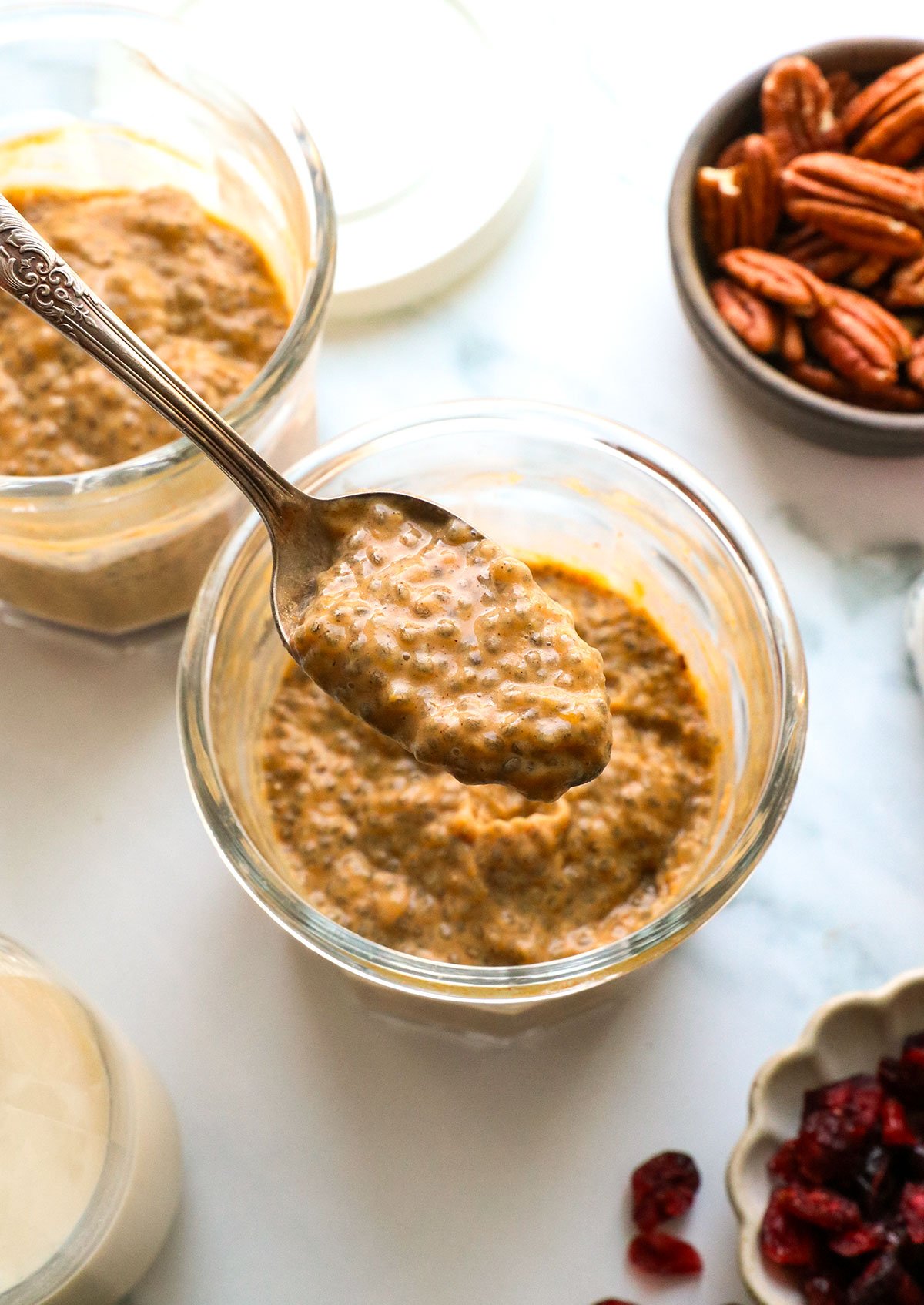 pumpkin chia pudding lifted on a spoon from a jar.  - 2