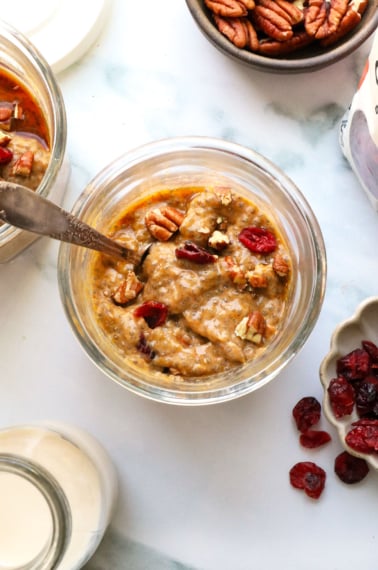 thick pumpkin chia pudding topped with pecans and dried cranberries.