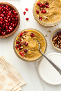 Pumpkin chia pudding topped with pomegranate seeds and pecans.