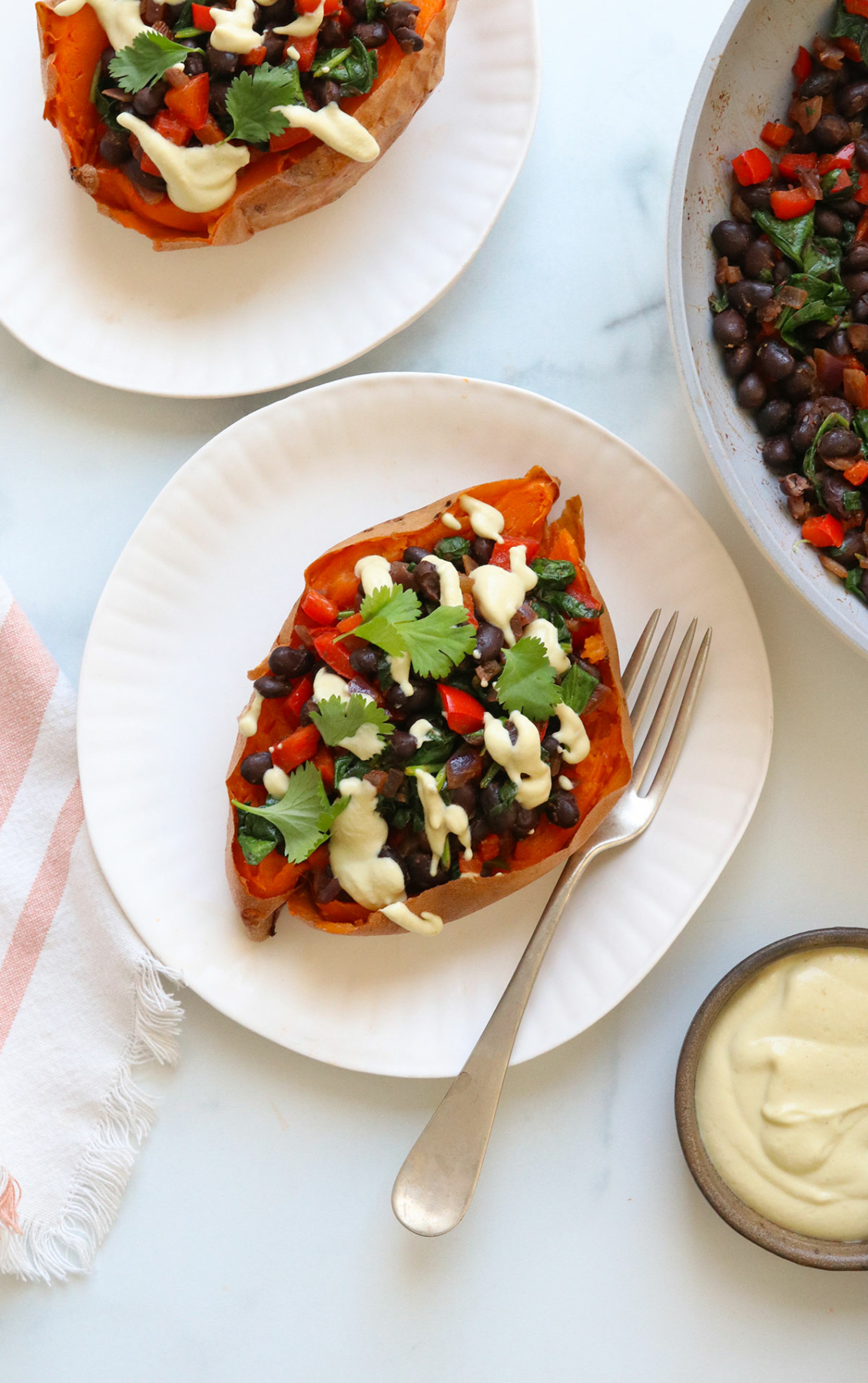 sweet potato stuffed with black beans and topped with cashew cheese sauce.