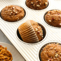 sweet potato muffins in their wrappers turned in a muffin pan.