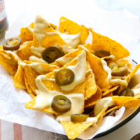 vegan nacho cheese served on tortilla chips with jalapenos.