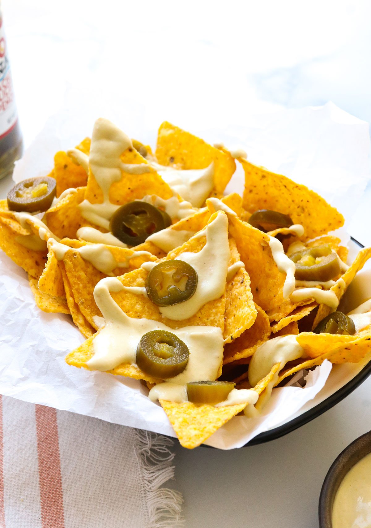 vegan nacho cheese served on tortilla chips with jalapenos.