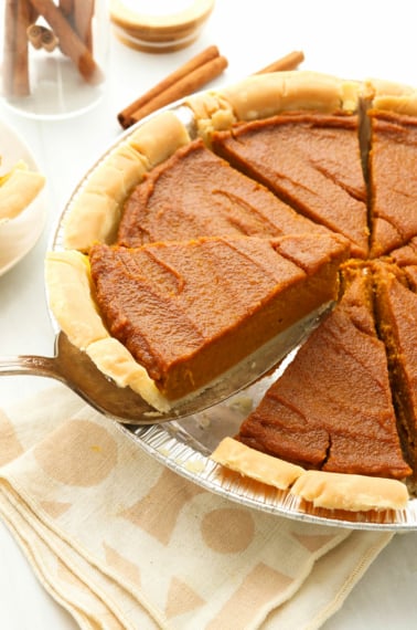 vegan pumpkin pie sliced and lifted up from the pan.