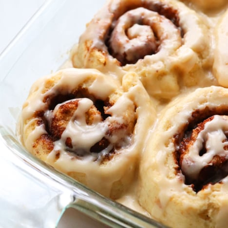 the best gluten-free cinnamon rolls in a glass pan topped with frosting.