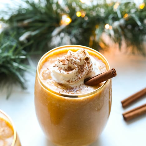 Vegan eggnog topped with whipped cream and cinnamon.