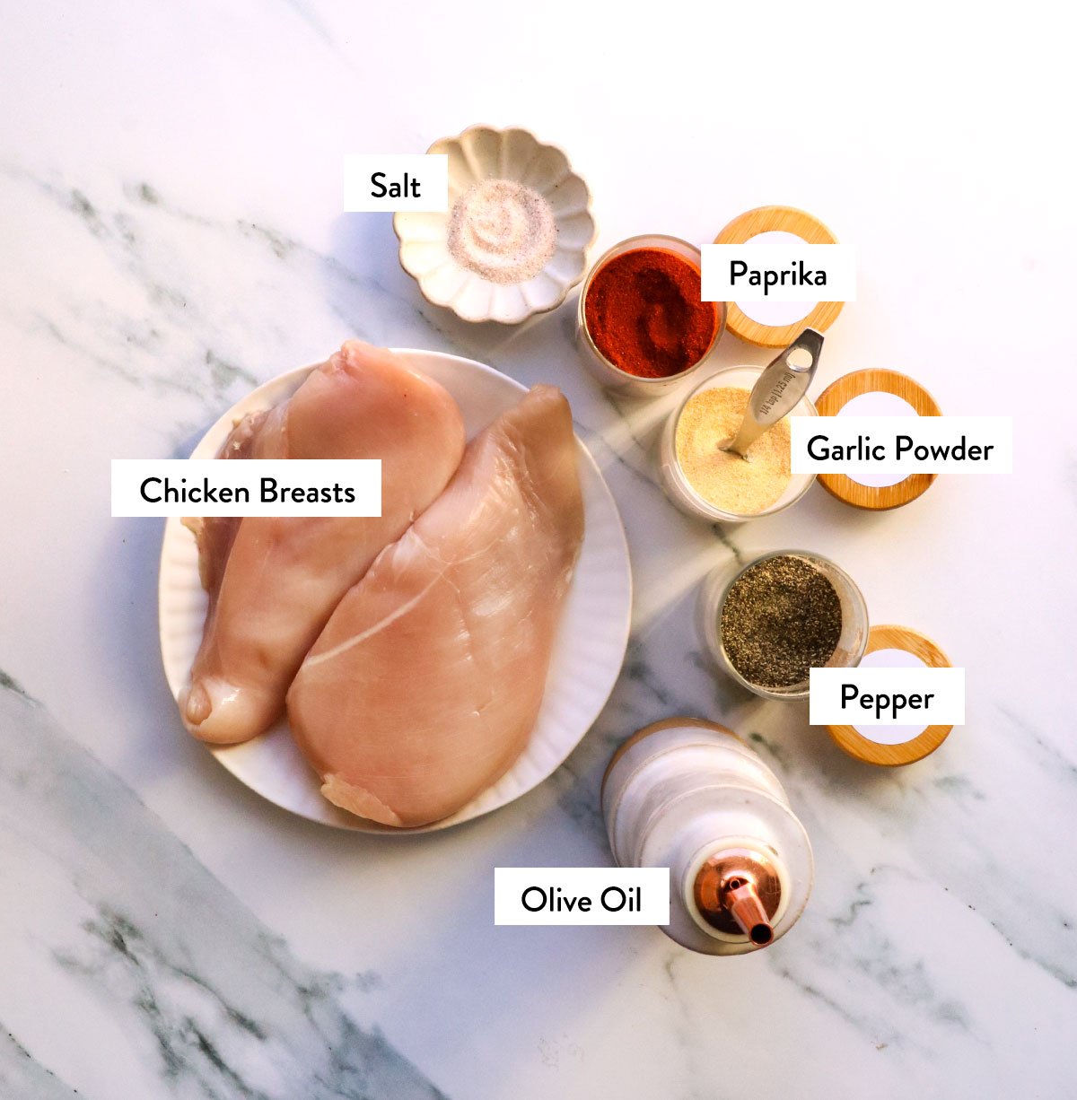 chicken breast, salt, garlic powder, paprika, pepper, and olive oil labeled on a white surface.  - 3