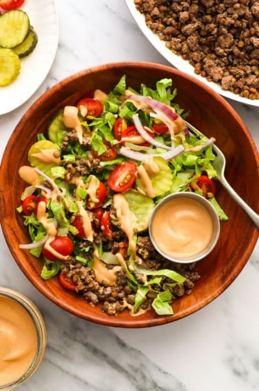 wooden bowl filled with ground beef, lettuce, and special sauce.