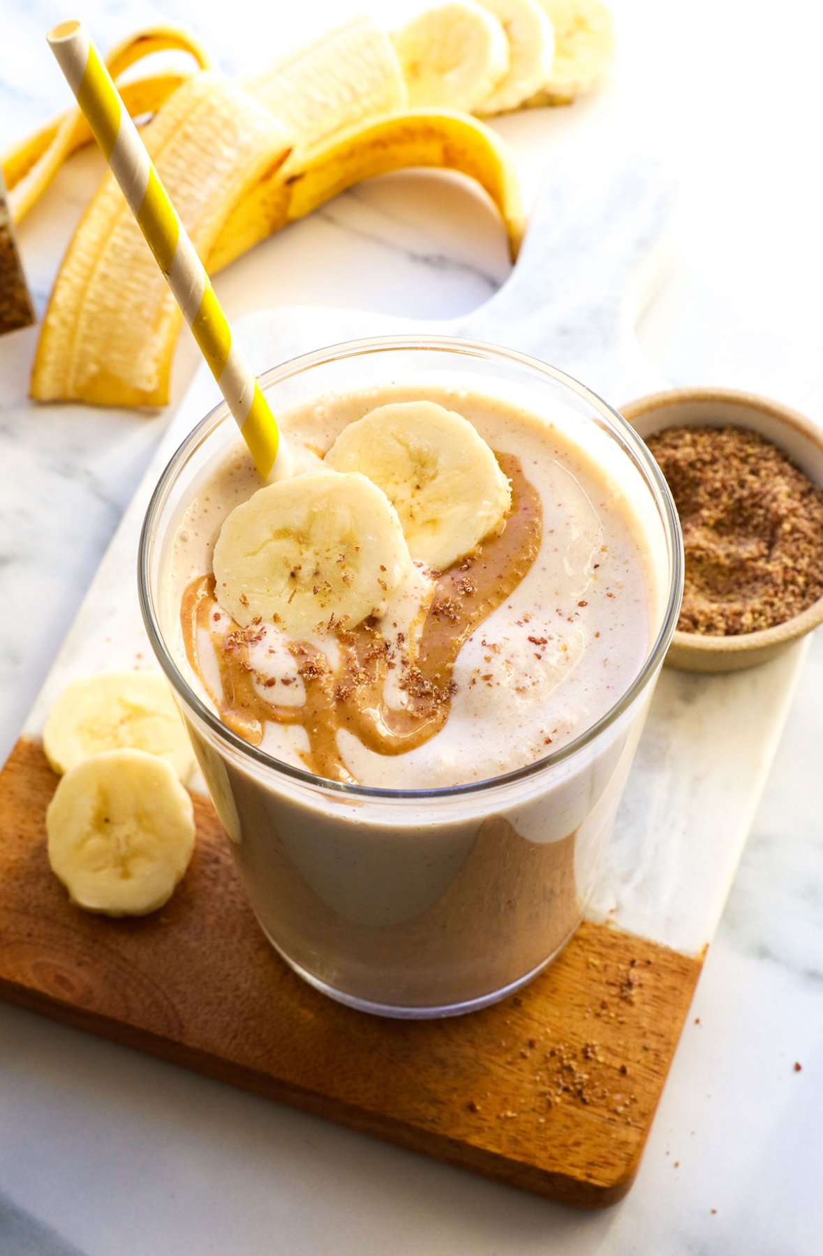 smoothie in a glass topped with peanut butter and banana slices.