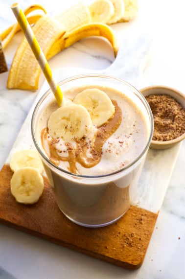 smoothie in a glass topped with peanut butter and banana slices.