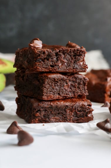 avocado brownies stacked with a black background.