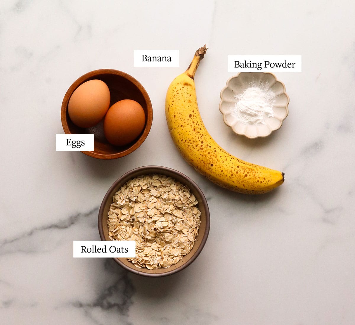 banana eggs and oatmeal labeled on a marble surface.