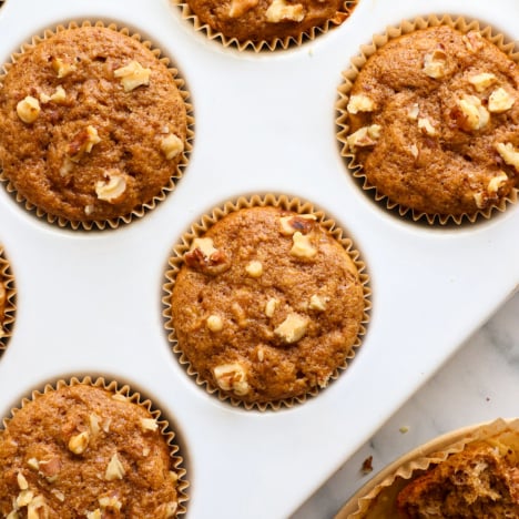 healthy banana muffins in a white ceramic muffin pan.