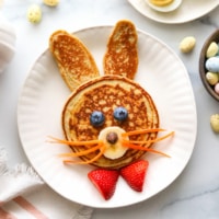 Pancakes decorated like a bunny with carrot whiskers.