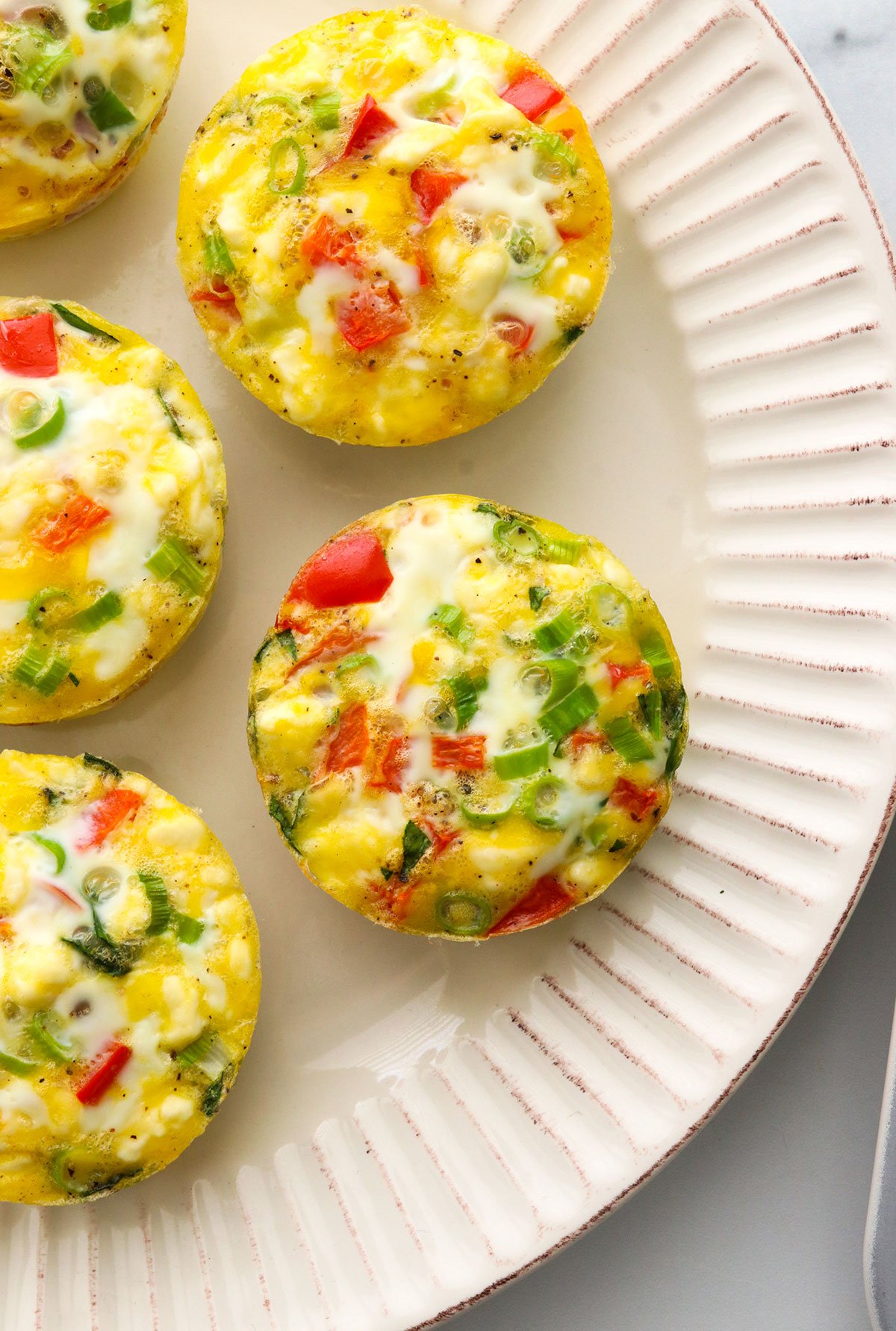 Egg muffins cooling on a white plate.