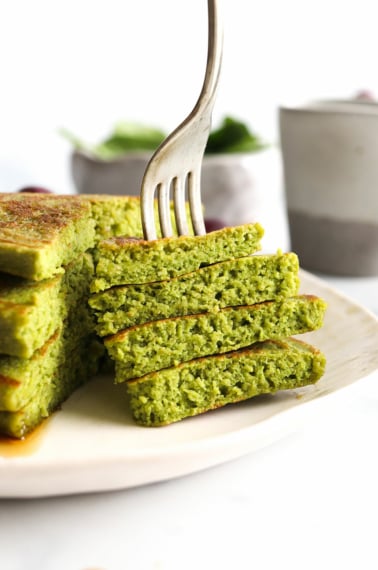 Spinach pancakes sliced with a bite on fork.