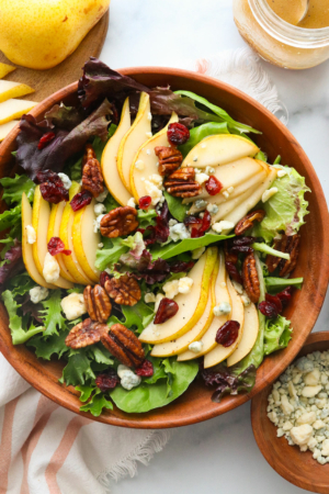 pear salad served with cranberries and pecans on top.