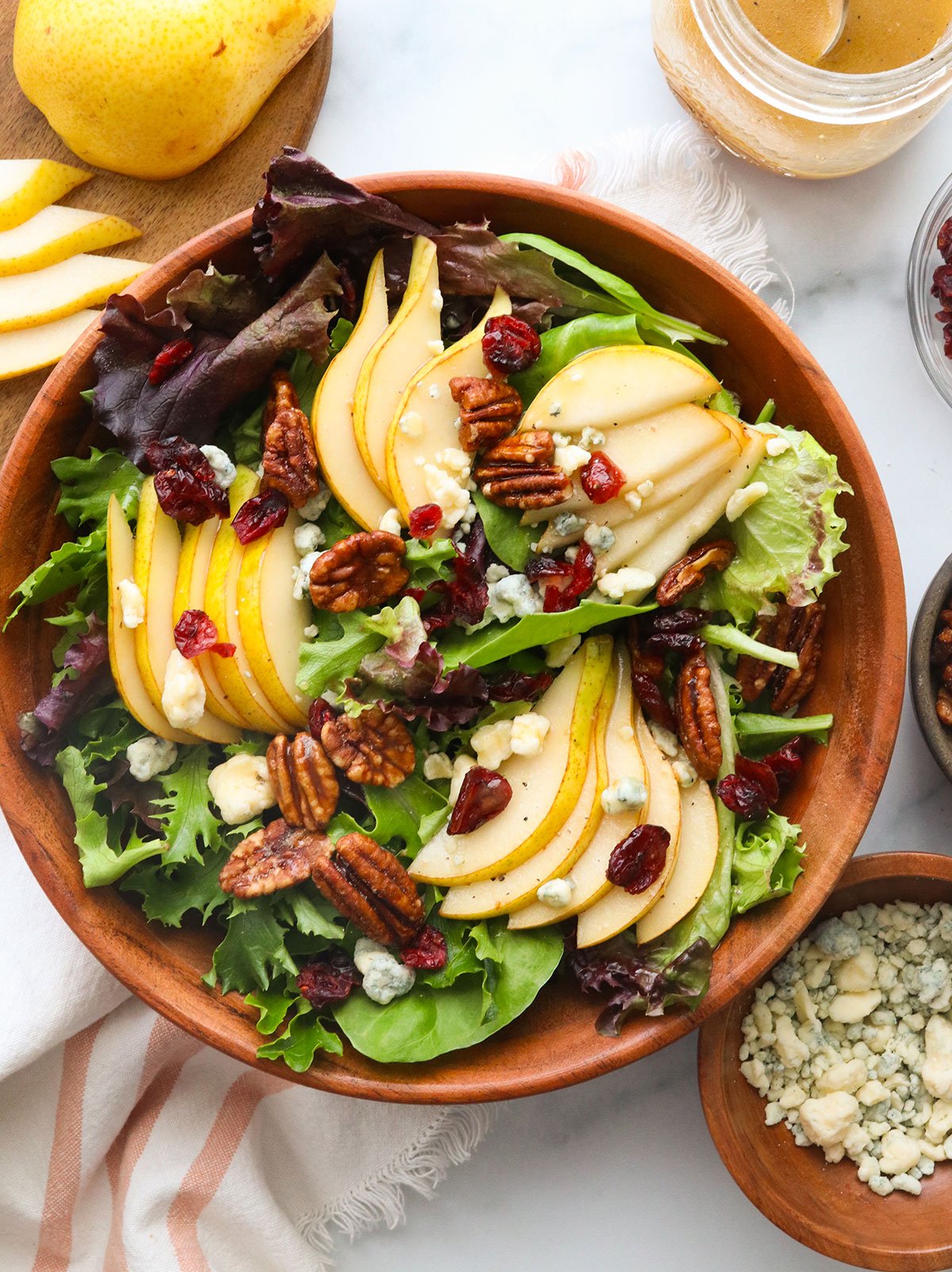 pear salad served with cranberries and pecans on top.