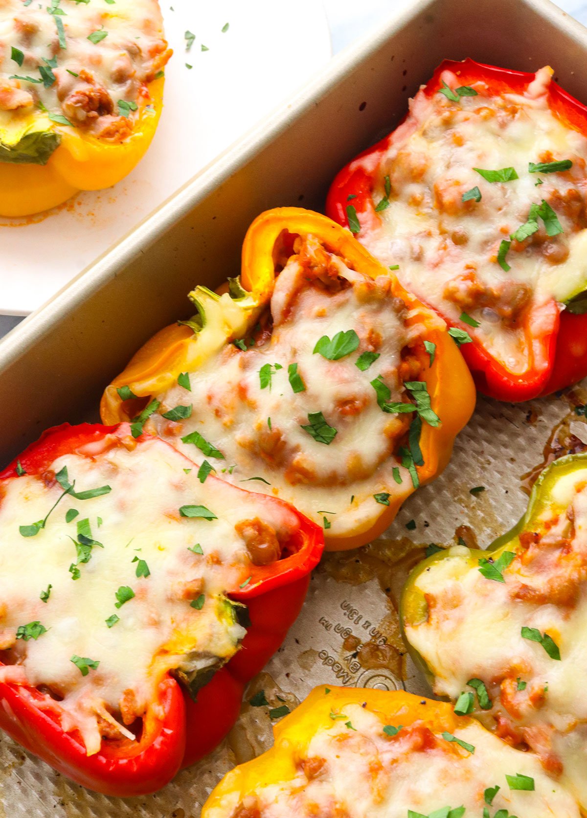 ground turkey stuffed peppers topped with mozzarella and parsley.