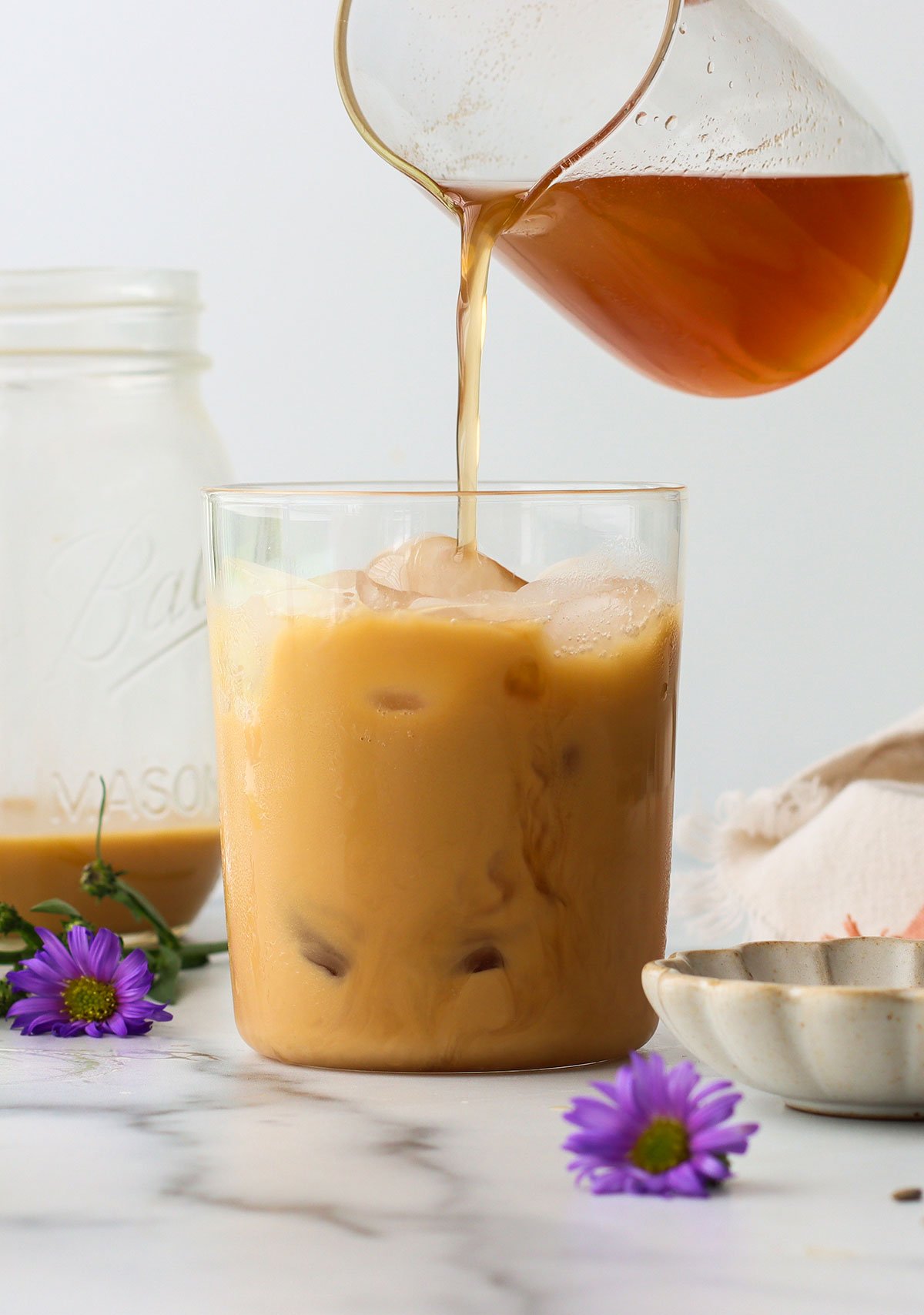 lavender syrup poured into an iced latte.