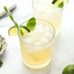 mojito mocktail in two glasses with lime slice as a garnish.