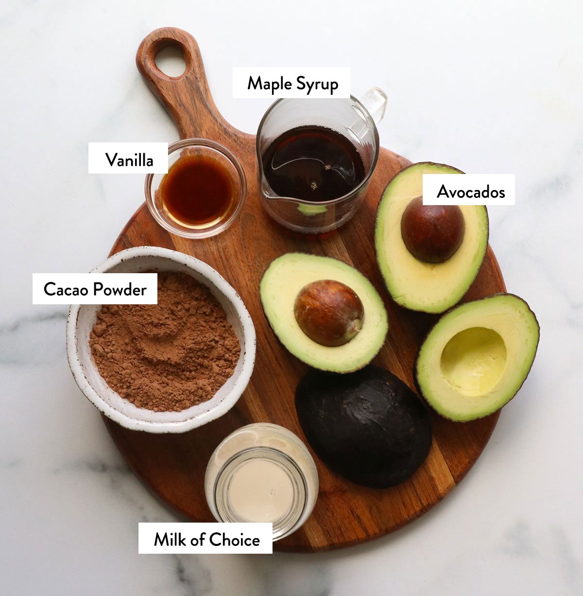 Avocado, milk, maple syrup and cocoa powder mark in a bowl.